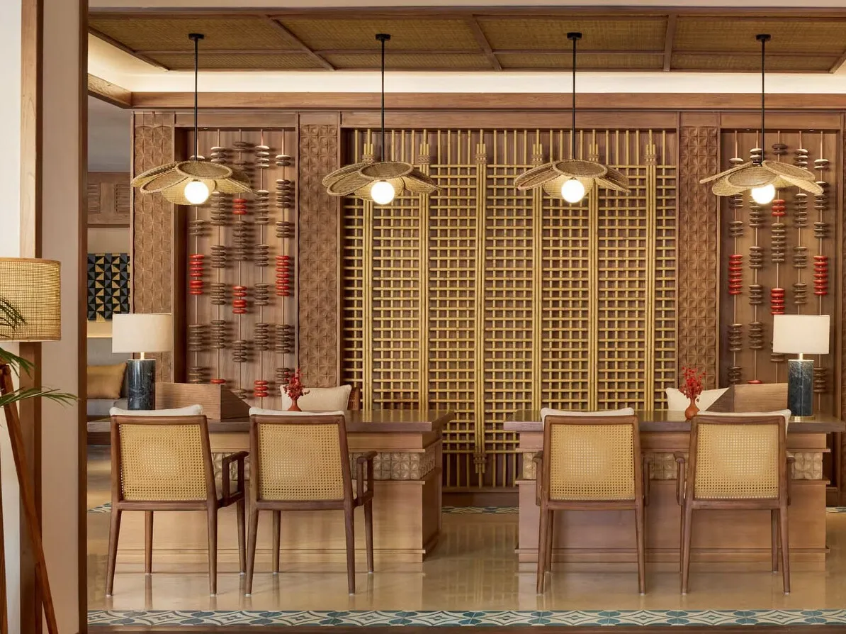 Reference image: a dining room with rattan-backed chairs, a carved timber screen wall and woven pendant lamps.