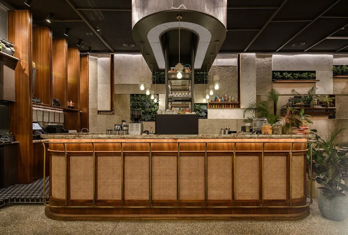 Reference image: a restaurant bar counter faced in rattan panels and timber, under a dark ceiling with a hanging hood.