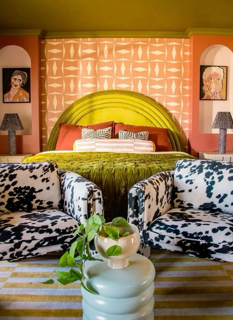Reference image: a coral bedroom with a diamond-patterned wall, a chartreuse arched headboard and two cow-print armchairs.